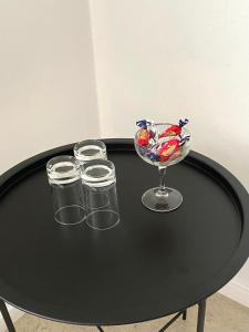 un tavolo nero con bicchieri e una ciotola di caramelle di Gullringens Värdshus & hotell a Gullringen