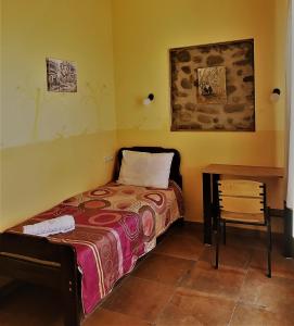 a small bedroom with a bed and a table at Telavi Tel Aviv in Tʼelavi