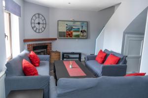 UN PASEO POR LAS NUBES في إل إيسبينار: غرفة معيشة مع كنبتين زرقاوين وطاولة