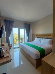 - une chambre avec un grand lit et une grande fenêtre dans l'établissement DEJAVU 2.0 HOTEL BAJO KOMODO, à Labuan Bajo