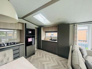 a room with a kitchen with a couch in it at Field View Lodge with Hot Tub in York