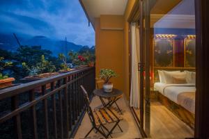 een balkon met een bed, een tafel en een raam bij Amritara Hidden Land, Gangtok - 900 mts from MG Marg in Gangtok +63 foto's