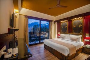 a bedroom with a bed and a large window at Amritara Hidden Land, Gangtok - 900 mts from MG Marg in Gangtok