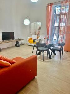 un soggiorno con divano rosso e tavolo in vetro di Volare House a Bari