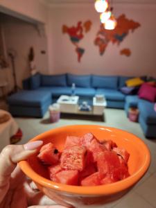 a person holding a bowl of watermelon in a living room at "sara accommodation room "no Egyptians "Dormitory room in Cairo