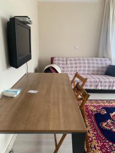 a living room with a wooden table and a tv at Rize manzara evi 