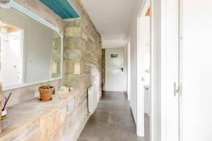 a hallway with a stone wall and a mirror at Casa Rural Hostel dos Lucas in Biescas +54 photos