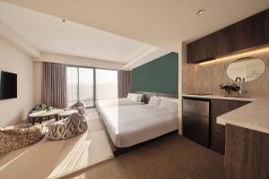 Habitación de hotel con cama y espejo en FAV LUX Hida Takayama, en Takayama