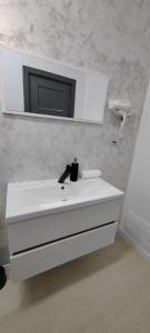 y baño con lavabo blanco y espejo. en Casira Guesthouse, en Sînmartin