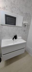 a bathroom with a white sink and a mirror at Casira Guesthouse in Sînmartin