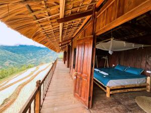 een kamer met een bed op een houten terras bij Lagom Su Phi Retreat in Hoàng Su Phì