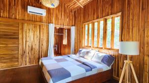 1 dormitorio con 1 cama en una habitación de madera en Baan Bhuwann Forest Chalet, en Ko Pha Ngan