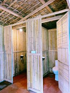 een badkamer met een toilet en bamboemuren bij Lagom Su Phi Retreat in Hoàng Su Phì