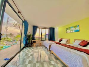Cu Lao ThuにあるVila Ánh Dươngのベッド2台とバルコニーが備わるホテルルームです。
