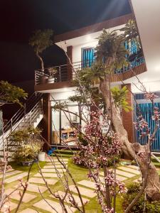 a house with a palm tree in front of it at Vila Ánh Dương in Cu Lao Thu