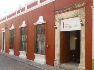 un edificio rojo con ventanas y un cartel en él en Hotel Maya Ah Kim Pech en Campeche