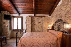 a bedroom with a bed in a room with stone walls at Volver B&B Spoleto in Spoleto
