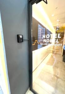 uma porta com um sinal na lateral de um edifício em HOTEL NOBEL CENTER em Tirana