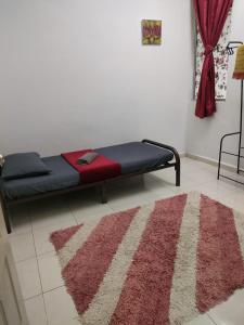 a bed in a room with a rug on the floor at HOMESTAY HAIKALHAIDAR in Rantau Panjang