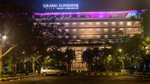 a car parked in front of a building at night at Grand Sunshine Resort & Convention in Bandung