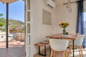 Un comedor con mesa y sillas y un balcón. en Casa Palmeras, en Almuñécar
