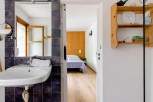 1 dormitorio con 1 cama y baño con lavabo. en Rural Hostel dos Lucas, en Biescas