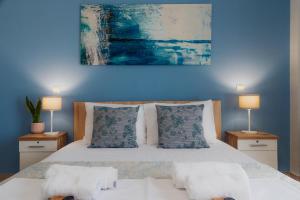 a blue bedroom with a bed with two lamps at Case d ' oro in Lefkímmi