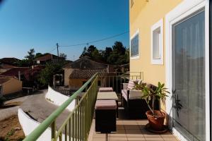 a balcony with a table and chairs on a house at Case d ' oro in Lefkímmi +89 photos