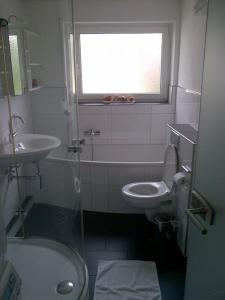 a bathroom with a sink and a toilet and a window at #1 Ferienwohnung Hochparterre in Friedrichshafen