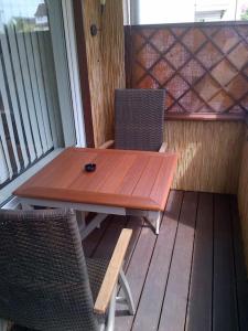 a wooden table and two chairs on a porch at #1 Ferienwohnung Hochparterre in Friedrichshafen