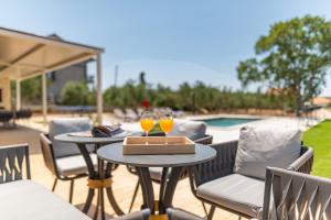 a patio with two tables with glasses of orange juice at Villa New Life Zadar in Sukošan