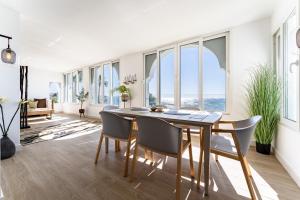 Un comedor con mesa y sillas y grandes ventanales. en 219 Frontline beach Luxurious, en Mijas Costa