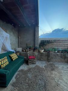 un sofá verde y una silla en el patio en Ca la Traviesa - Refugio del Arte - Pet Lovers - Adults Only - Montsant, en Bellaguarda
