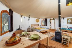 uma sala de estar com uma mesa e uma cama numa tenda em Eco Yurta Lanjarón em Lanjarón