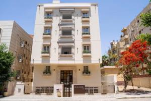 a tall white building with windows and balconies at Dream House in 6th Of October