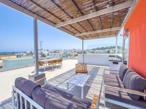 een patio met een bank en een tafel op een dak bij Geo Panoramic Villa +Pool +Game Room +Gym in Protaras