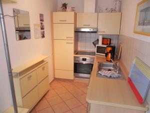 アールベックにあるFEWO am Wilhelmsberg EG01の小さなキッチン(白いキャビネット、カウンタートップ付)
