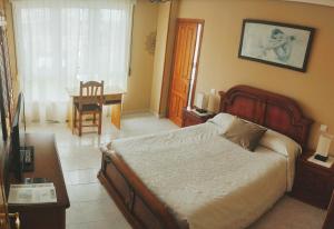 a bedroom with a bed and a table and a chair at Alto Santiago in San Vicente de la Barquera