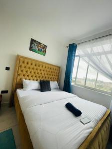 1 dormitorio con 1 cama grande y ventana grande en Omuts one bed airbnb with swimmingpool en Kiambu