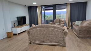 sala de estar con 2 sillas y TV de pantalla plana en Casa montagna Markovica, 