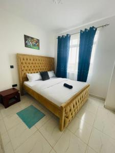 1 dormitorio con 1 cama grande y cortinas azules en Omuts one bed airbnb with swimmingpool en Kiambu
