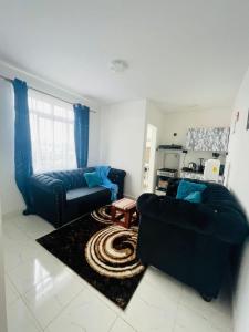 a living room with a couch and a table at Omuts one bed airbnb with swimmingpool in Kiambu