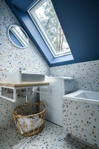 a bathroom with a sink and a window at W Kaszubskim Lesie Borsk in Borsk