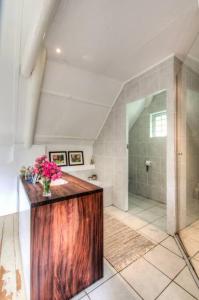 a bathroom with a wooden counter with flowers on it at Little Oak Cottage in Greyton