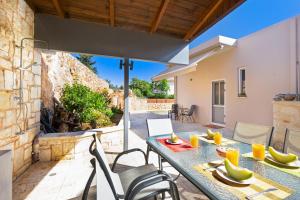 un patio avec une table et des chaises et un bâtiment dans l'établissement Vrahokipos Villa, à Kounoupidhianá