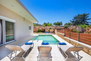 un patio con sillas y una piscina en Vrahokipos Villa en Kounoupidhianá