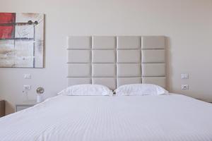 ein großes weißes Bett mit zwei Kissen darauf in der Unterkunft Queen Hotel in Sesto San Giovanni
