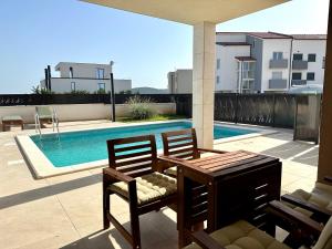 a patio with two chairs and a table and a pool at Apartment with private pool Mukalba in Medulin