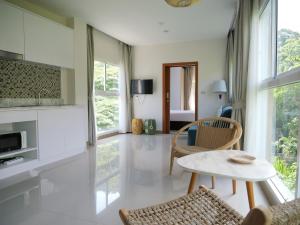 a living room with a table and some chairs at Karon beach apartment & sea view pool in Ban Karon
