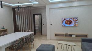 una stanza con tavolo e sedie e un dipinto sul muro di vacance et confort les sablettes a Mohammedia